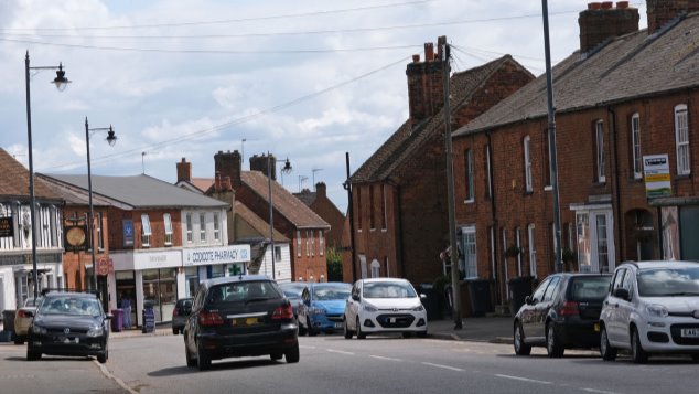 The High Street showing different shops and a pub, bus stop etc.