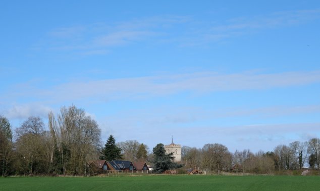 View 4 From Junction of Footpath 5 and 6 looking north west to St Giles - grass field in foreground with houses and church tower centre picture under a big blue sky