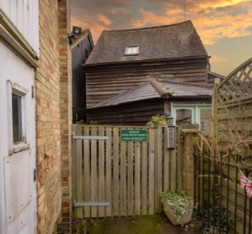 Wooden structure behind Peace Memorial Hall used as a Men's club but currently housing the village museum