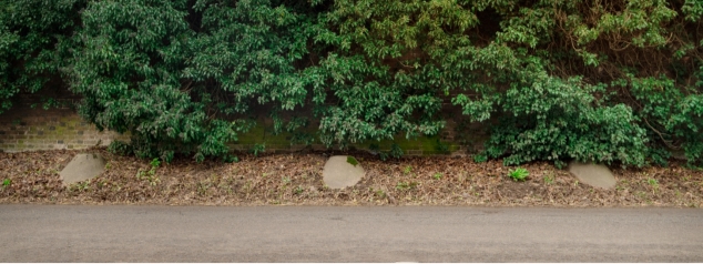 Three concrete bollards in the verge beyond the pavement which were used to stop tanks in the Second World War