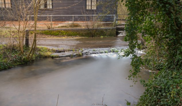 The river at Fulling Mill showing a raised level with slop that was used as a cart ramp with mill buildings behind